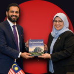 Meezan Bank's Mr. Shayan Ahmed Baig presenting the bank's history book to the Assistant Governor of Bank Negara Malaysia.