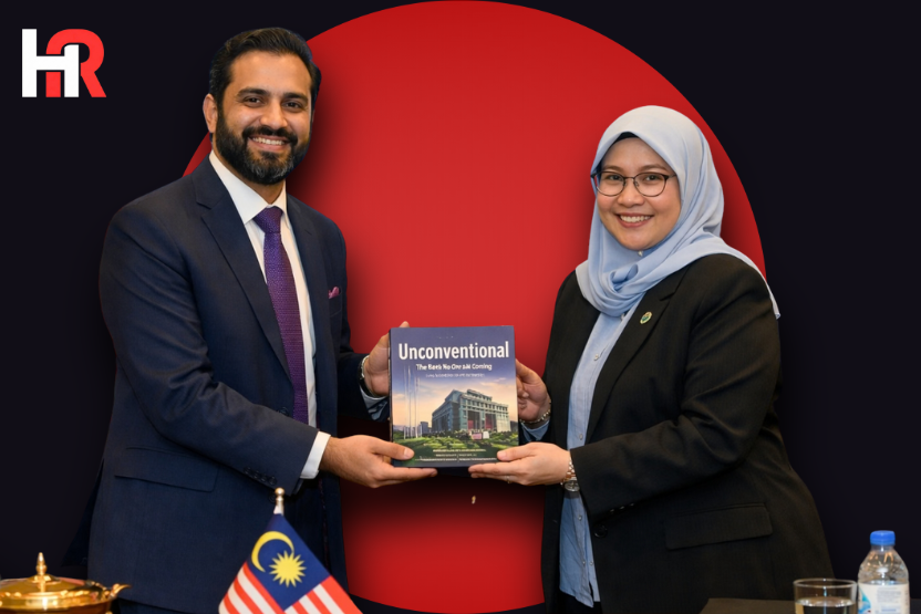 Meezan Bank's Mr. Shayan Ahmed Baig presenting the bank's history book to the Assistant Governor of Bank Negara Malaysia.