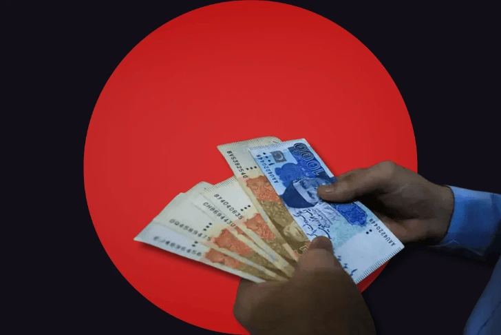 hands holding pakistani currency notes of five thousands and thousands