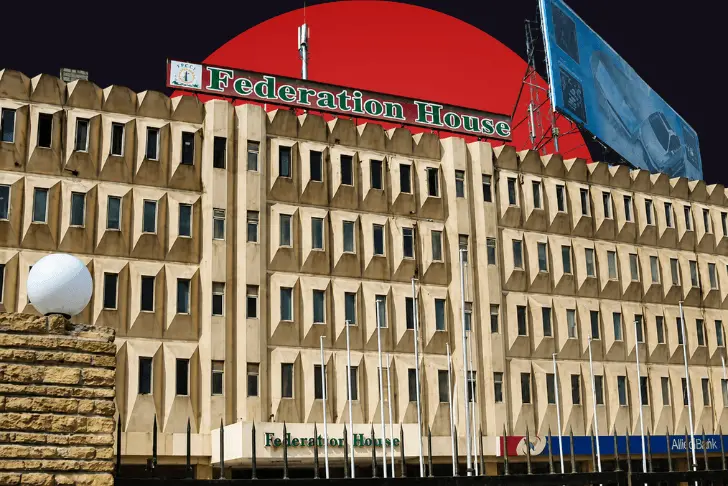 A brutalist, multi-story concrete building with a prominent "Federation House" sign on the roof, set against a dark sky dominated by a massive, solid red circle.
