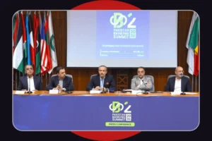A panel of five men in business attire seated behind a long desk during a press conference. Behind them, a large screen displays the logo for the 'Pakistan Banking Summit 2026,' indicating the event is at the Pearl Continental Hotel in Karachi. Several international flags stand on either side of the screen. The front of the desk is covered with a blue banner matching the summit's branding. The image is framed with rounded corners against a dark background with red semi-circles peeking out at the top and bottom.
