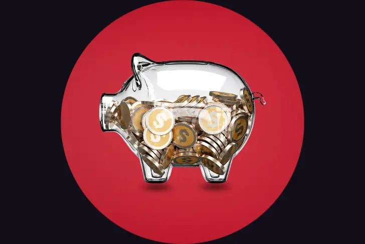 A transparent glass piggy bank partially filled with gold coins bearing the dollar symbol. The piggy bank is centered against a dark background featuring a large, solid red circle directly behind it.
