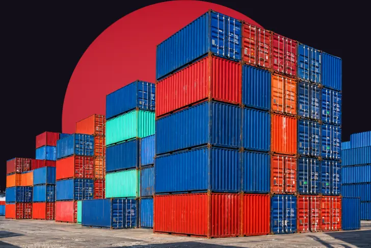 An industrial port scene featuring massive, towering stacks of colorful shipping containers in blue, red, and teal. The containers are set against a dark background with a large, solid red circle rising behind them.
